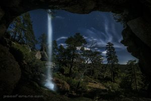 Fotografia nocturna de una cueva con una cascada en picos de urbion
